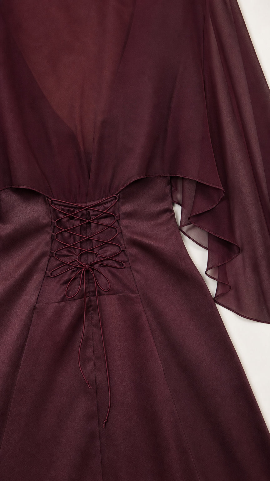 Close-up of intricate lace-up corset back on burgundy satin evening gown