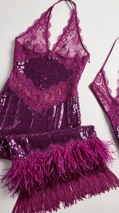 Detailed close-up of magenta halter dress showing sheer lace bodice, sequins, and feather fringe hem