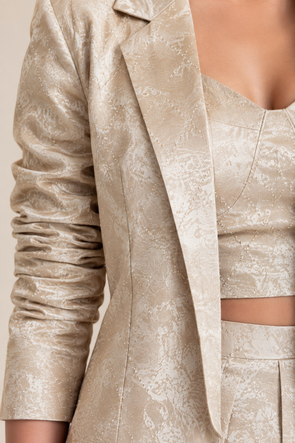 Close-up detail of Champagne shimmer jacquard fabric, blazer lapel, and sweetheart crop top