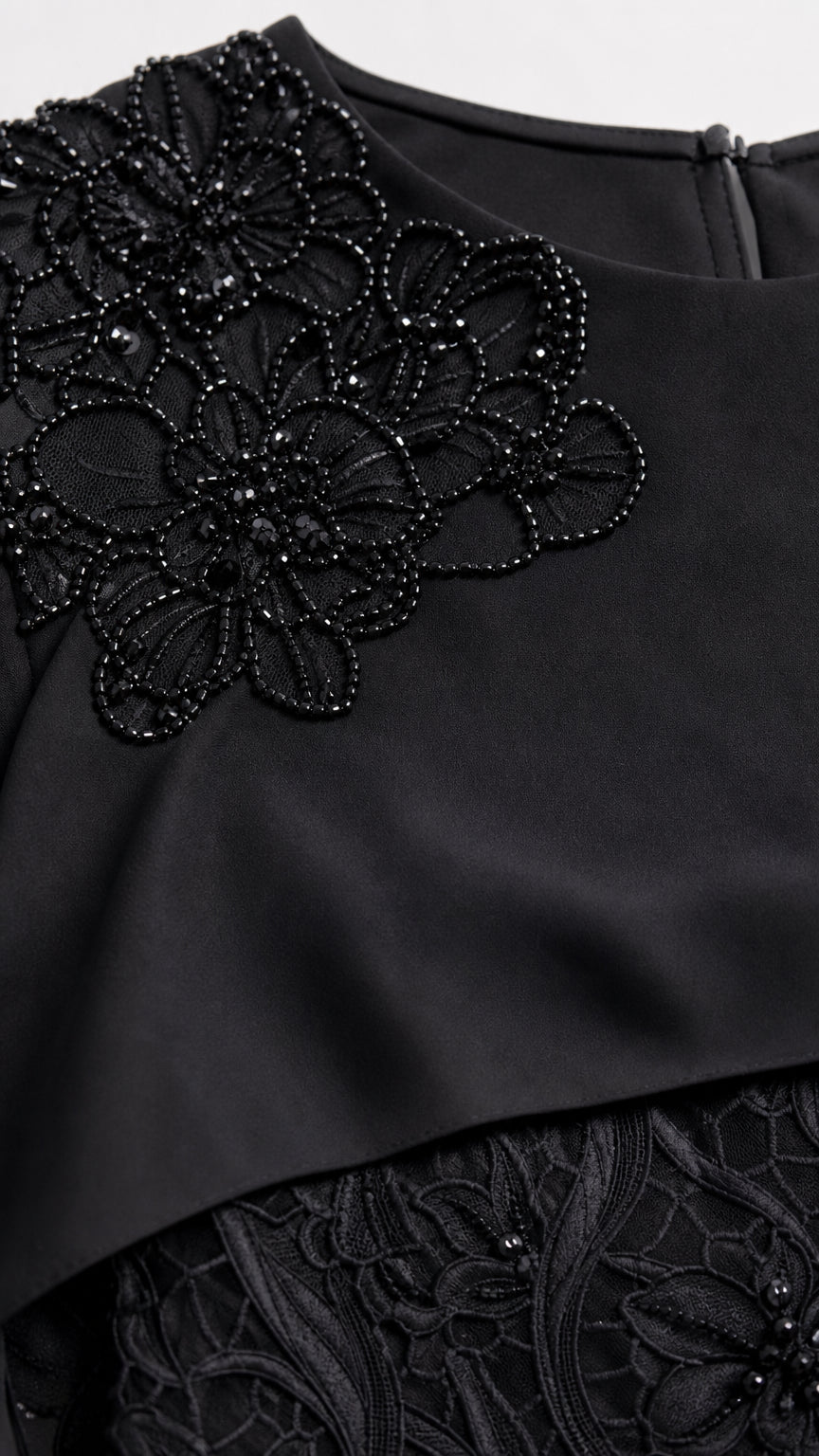 Close-up detail of floral beadwork embroidery on capelet neckline