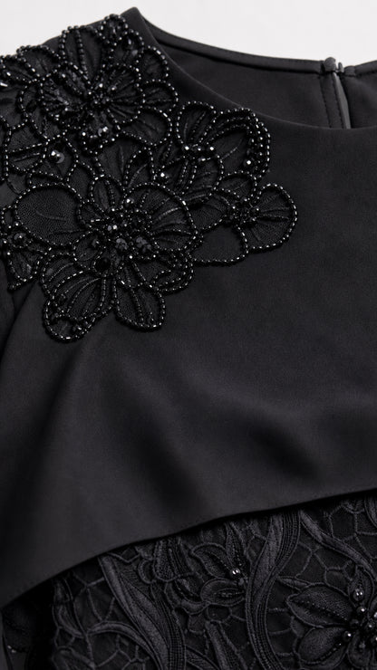 Close-up detail of floral beadwork embroidery on capelet neckline