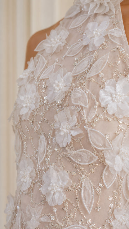 Close-up detail of 3D floral appliques and beaded embroidery on halter gown