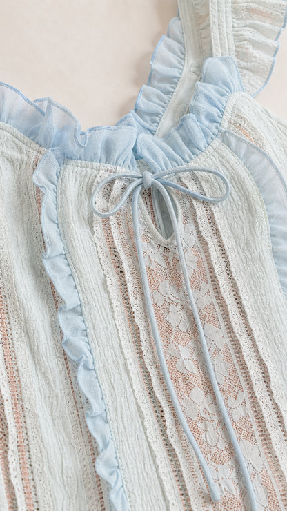 Close-up of bodice, ruffles, and front tie on light blue dress