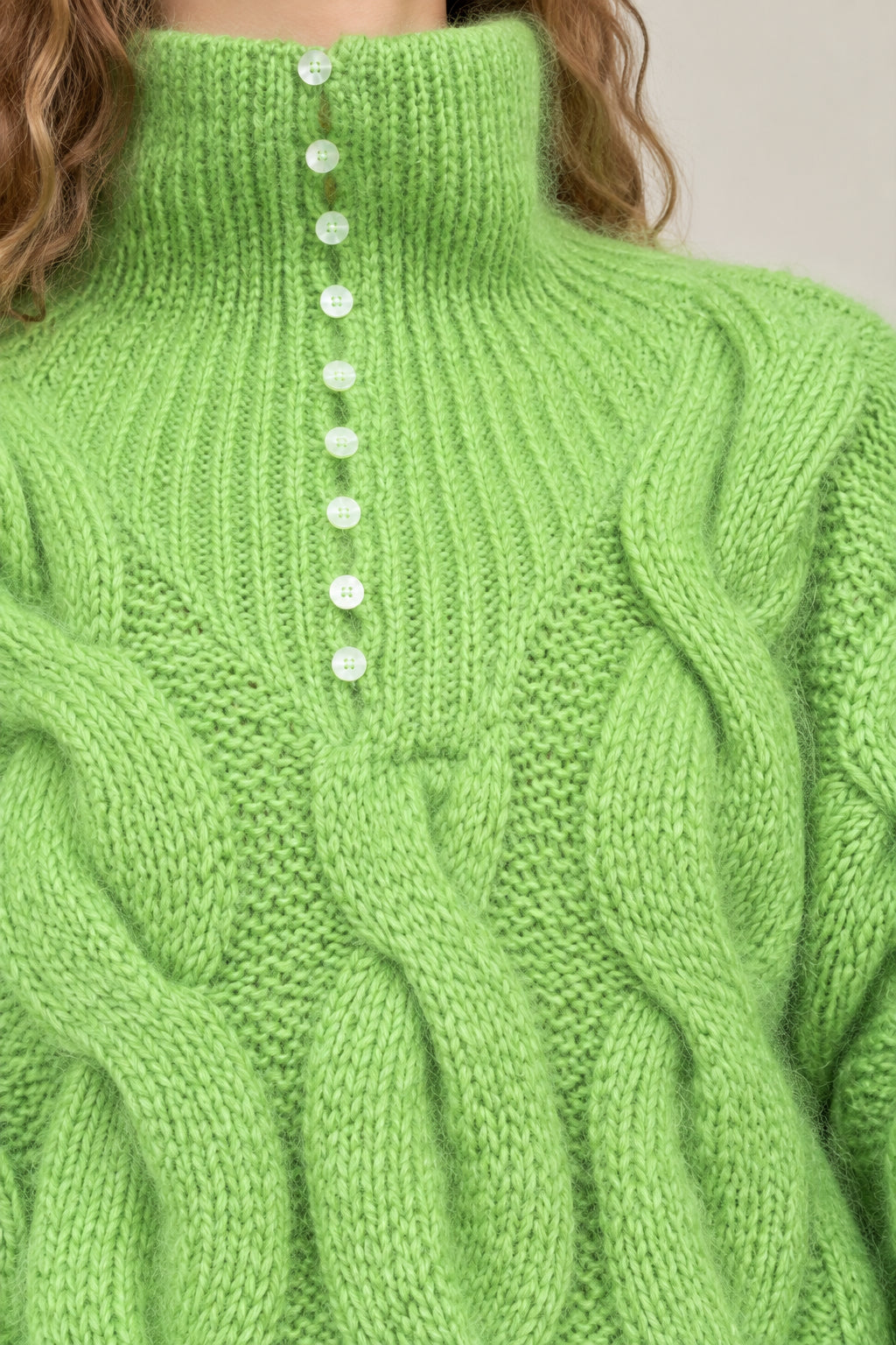 Close-up detail of lime green ribbed high neck collar and button placket