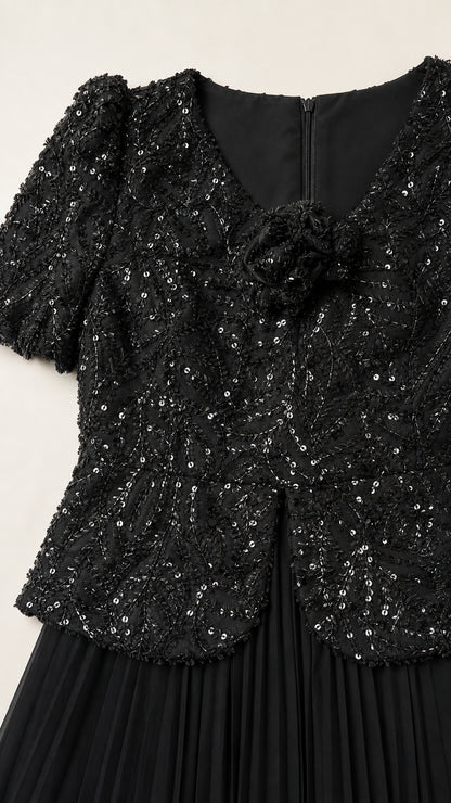 Close-up detail of black sequin bodice with 3D floral rosette and zipper back