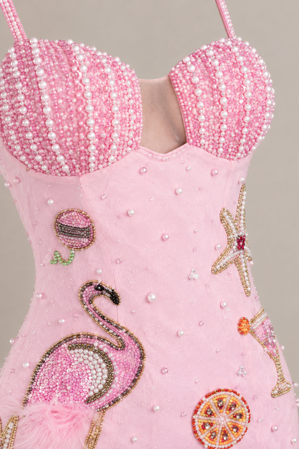 Close-up of beaded sweetheart bust and embroidered flamingo motif details