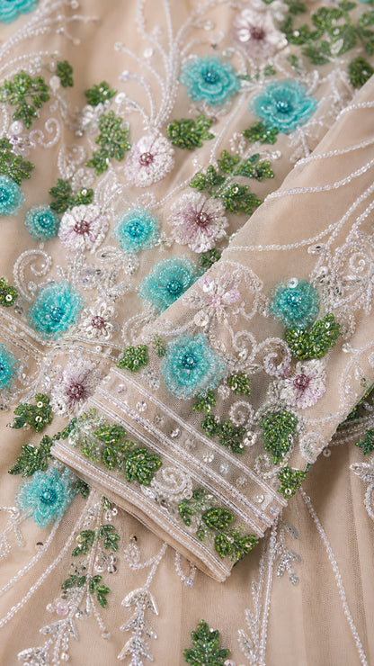 Close-up detail of teal and white floral beadwork and cuff embellishments
