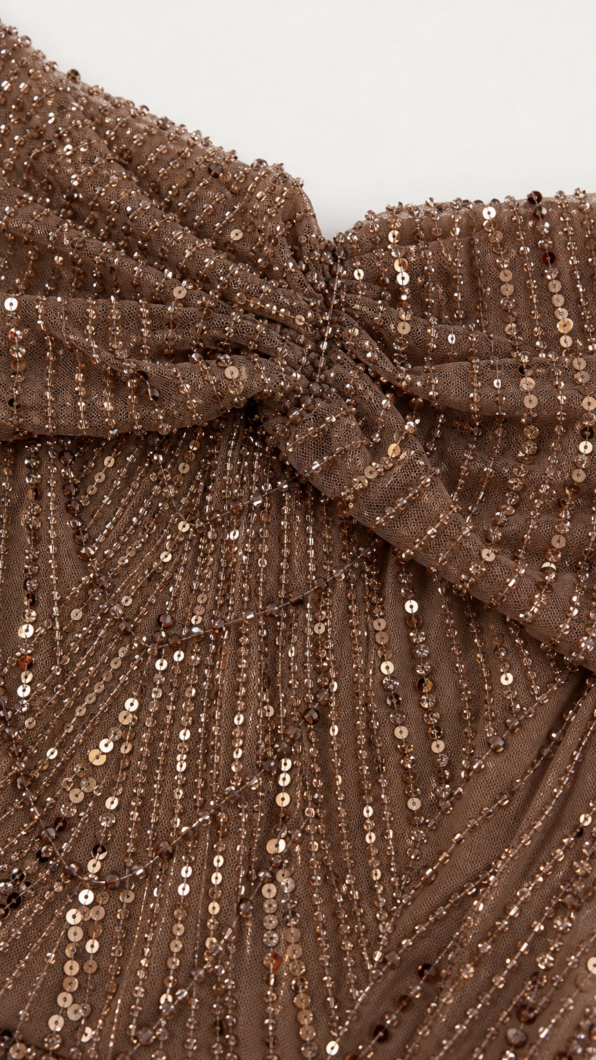 Close-up detail of draped neckline and shimmering sequin embroidery fabric