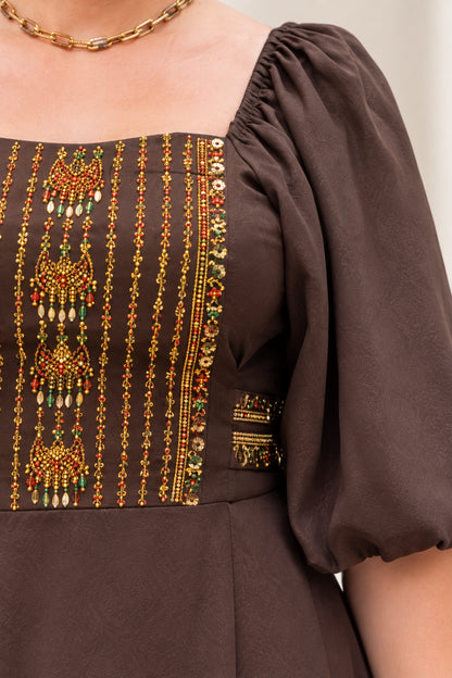 Close-up detail of embellished square neckline and puff sleeve on brown dress