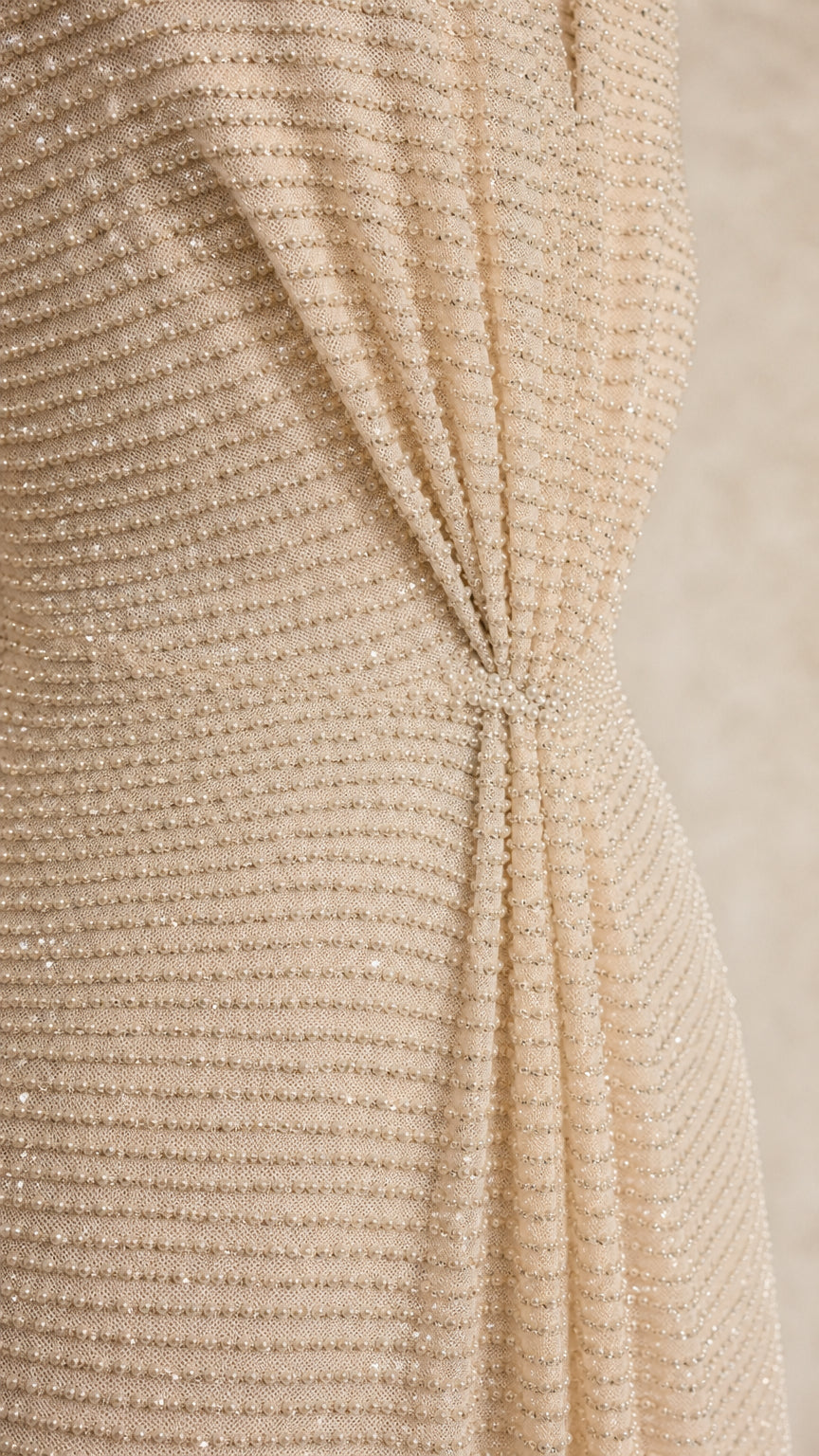 Close-up detail of textured fabric and front knot on champagne dress