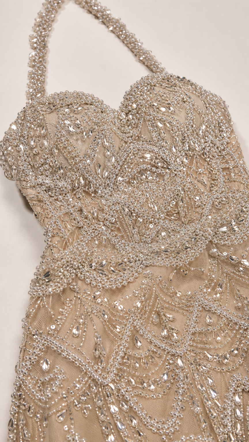 Close-up detail of crystal and bead embellishments on bodice and halter strap