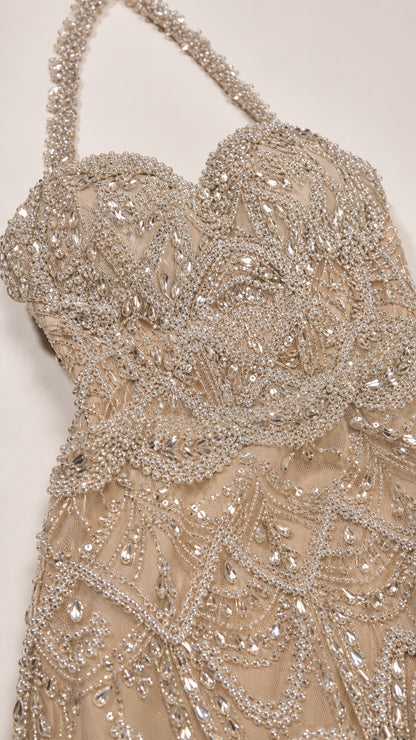 Close-up detail of crystal and bead embellishments on bodice and halter strap
