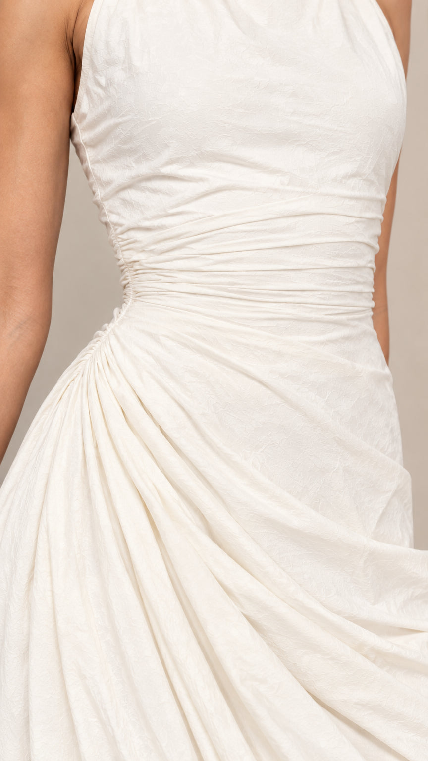 Close-up detail of ruching and fabric texture on ivory draped dress