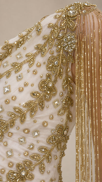Close-up detail of gold embroidery and fringe on gown shoulder