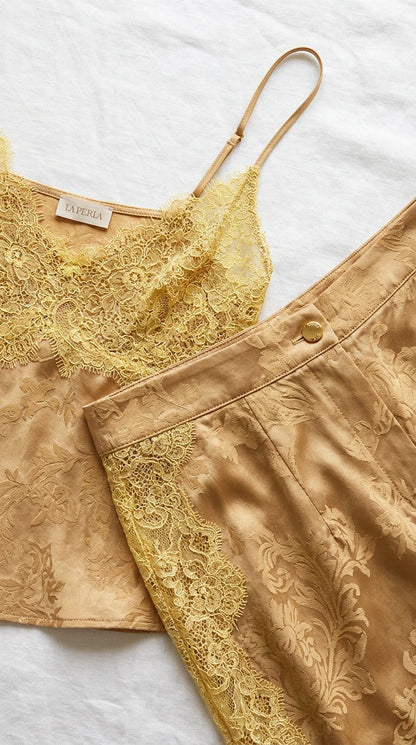 Flat lay close-up of champagne gold damask jacquard fabric and intricate yellow lace detailing