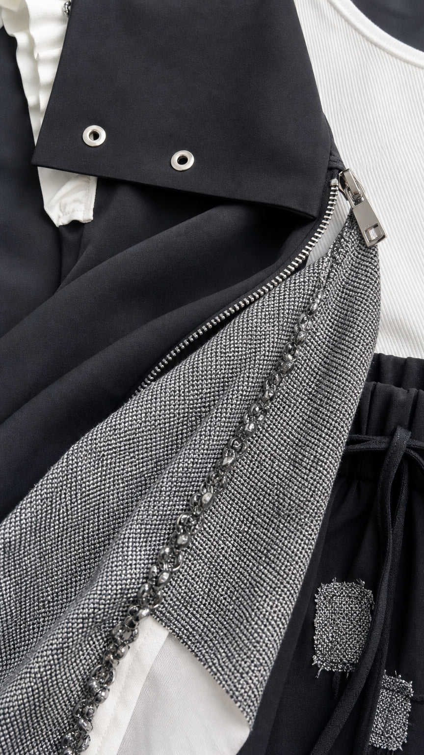 Close-up detail of vest neckline, snap collar, metal zipper, and beaded textured panel