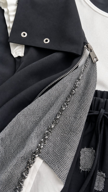 Close-up detail of vest neckline, snap collar, metal zipper, and beaded textured panel