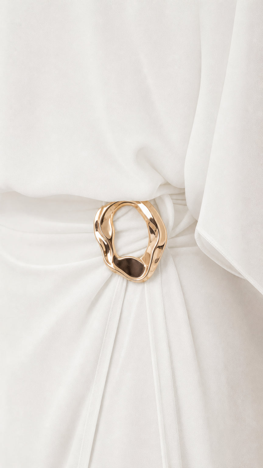 Close up of gold-tone metallic ring buckle and ruched waist detail