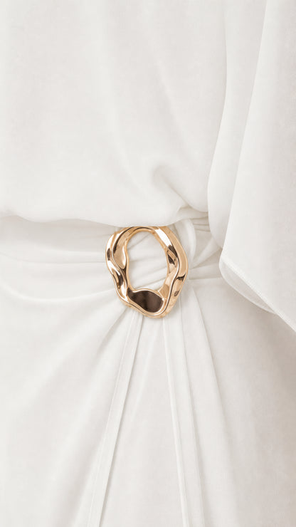 Close up of gold-tone metallic ring buckle and ruched waist detail