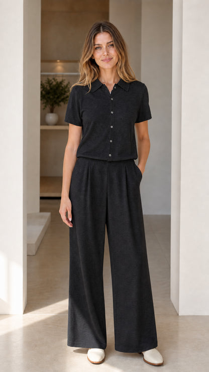 Full-length front view of black short sleeve polo and wide-leg pants matching set