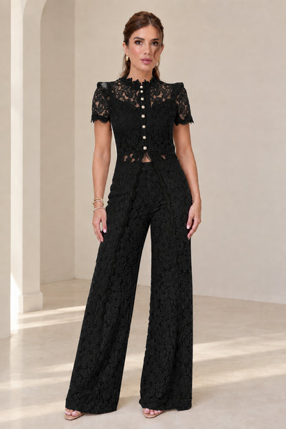 Model wearing black floral lace two-piece top and wide-leg pant set