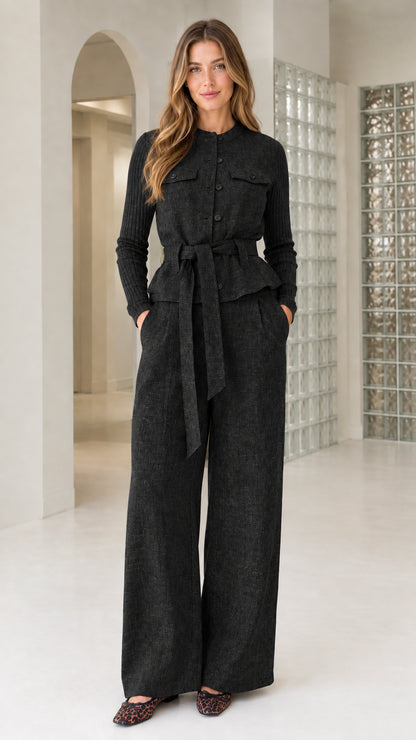 Front view of model wearing Black belted jacket and wide-leg trousers set