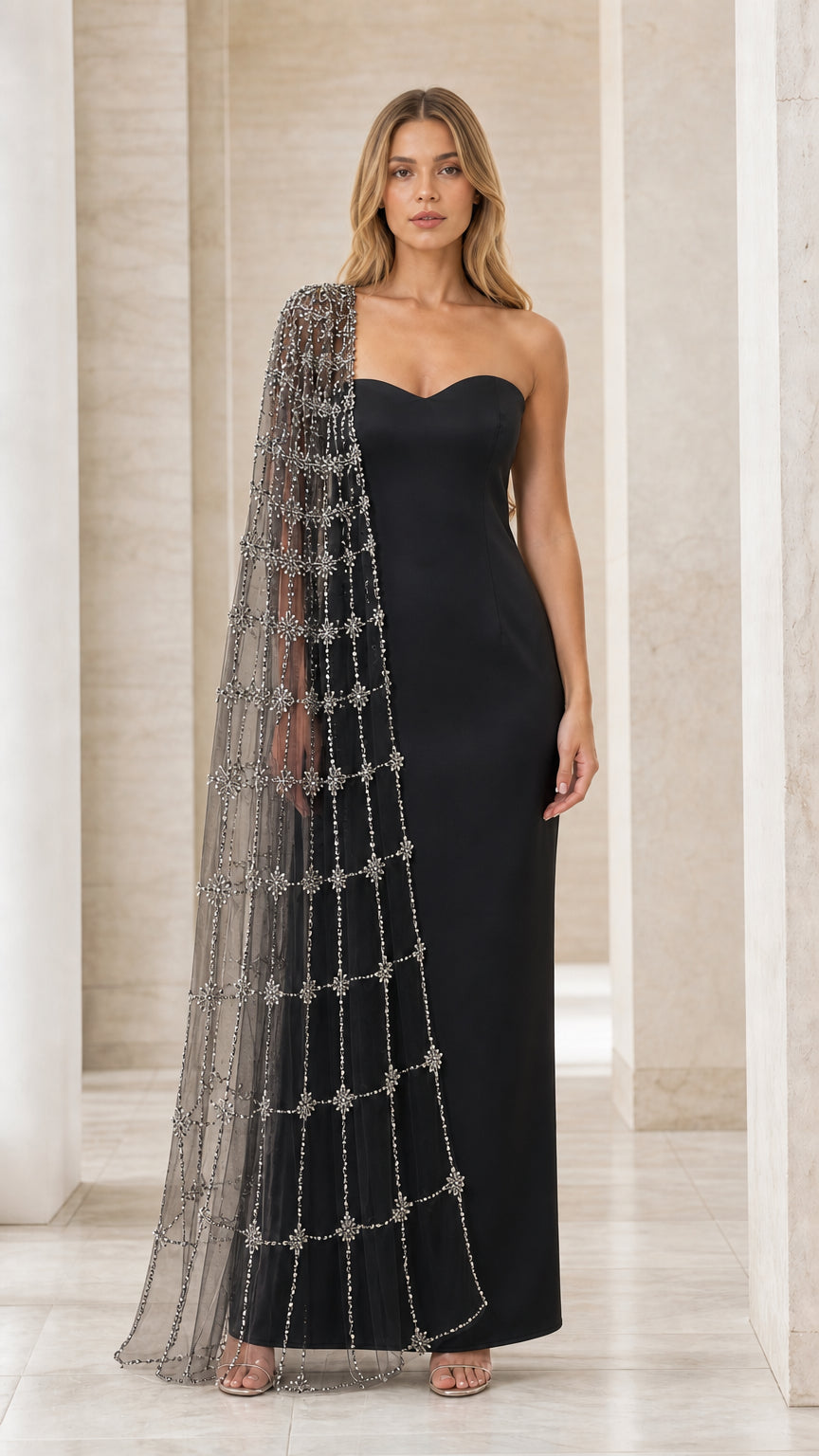 Model wearing black strapless sweetheart evening gown with matching sheer beaded cape