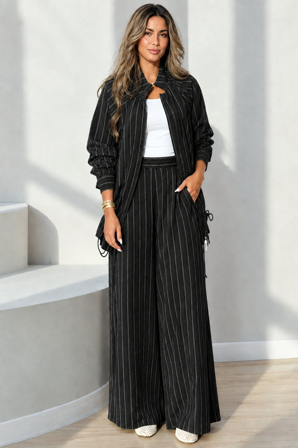 Full-length view of black pinstripe zip-up jacket and wide-leg pants set