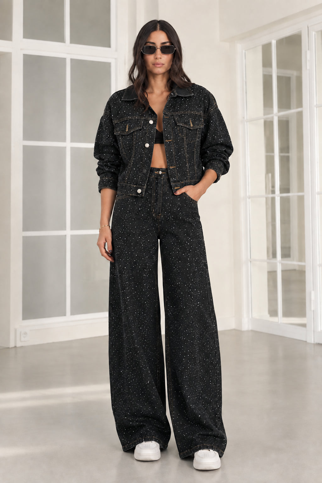 Model wearing black rhinestone denim cropped jacket and wide-leg pants two-piece set