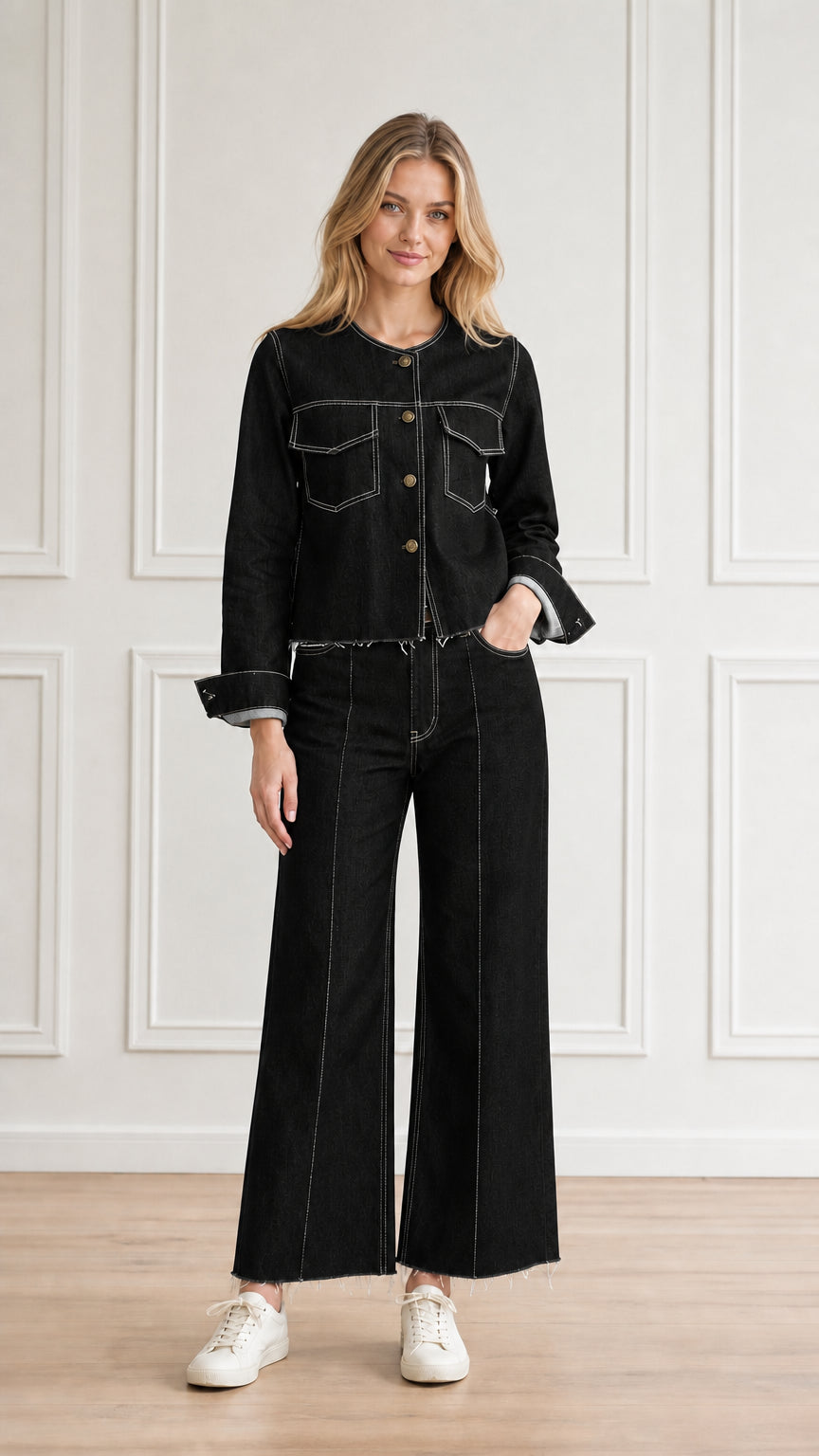 Model wearing black denim two-piece pant set with white contrast topstitching
