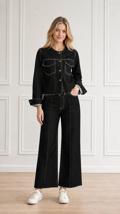 Model wearing black denim two-piece pant set with white contrast topstitching