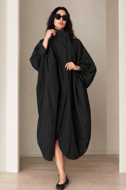 Model wearing black oversized cocoon long coat with high stand collar