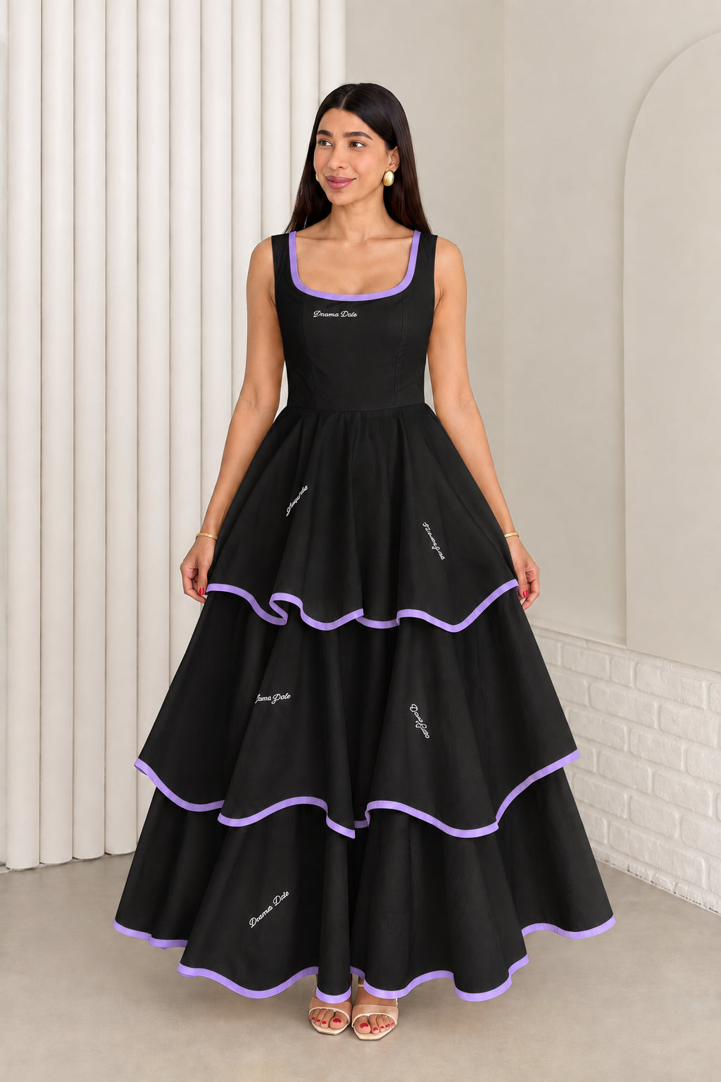 Model wearing black sleeveless tiered maxi dress with purple contrast trim
