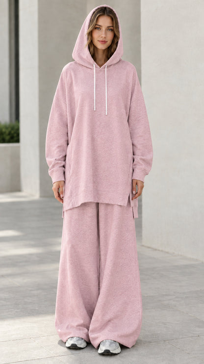 Woman wearing dusty pink hooded sweatshirt and wide-leg sweatpants matching two-piece set