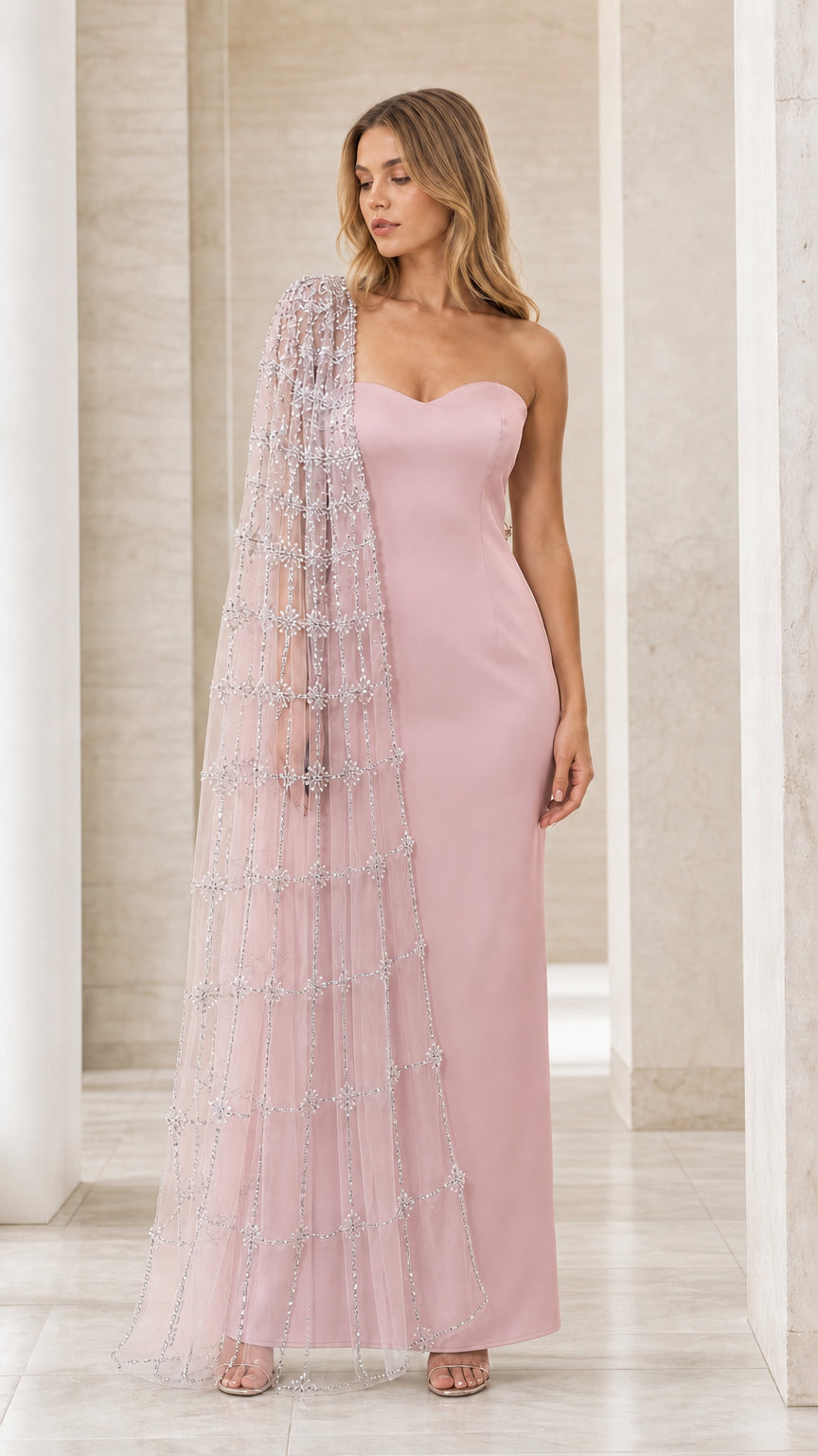 Model wearing blush pink strapless maxi dress with sparkling cape overlay