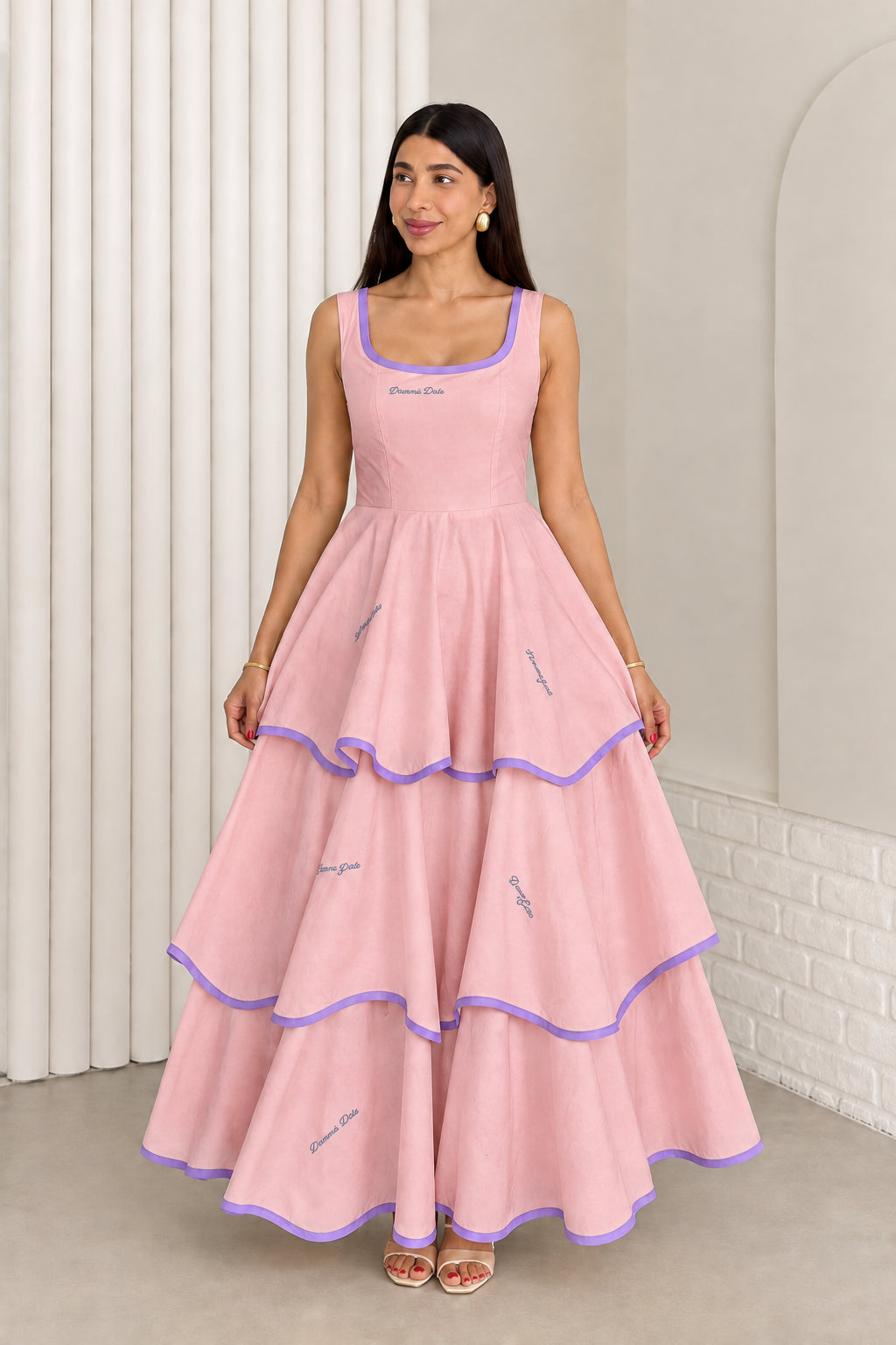 Model wearing dusty pink sleeveless tiered maxi dress with purple contrast trim