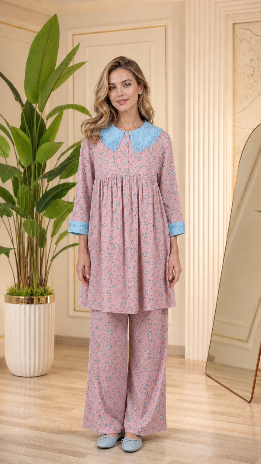 Model wearing dusty pink floral pajama set with light blue contrast collar and cuffs