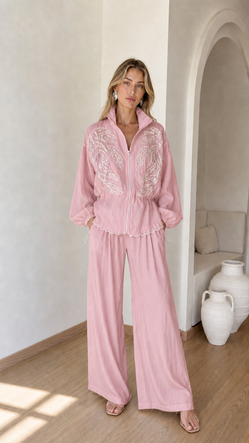 Front full view of woman wearing dusty pink embroidered zip jacket and wide-leg pants set