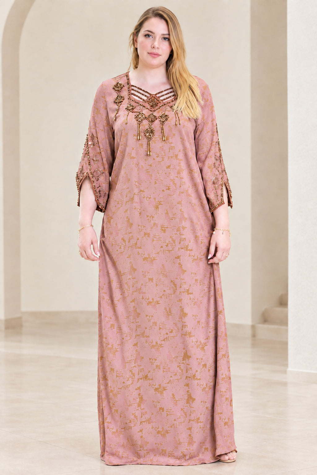 Front view of woman wearing dusty pink beaded strappy neckline kaftan dress