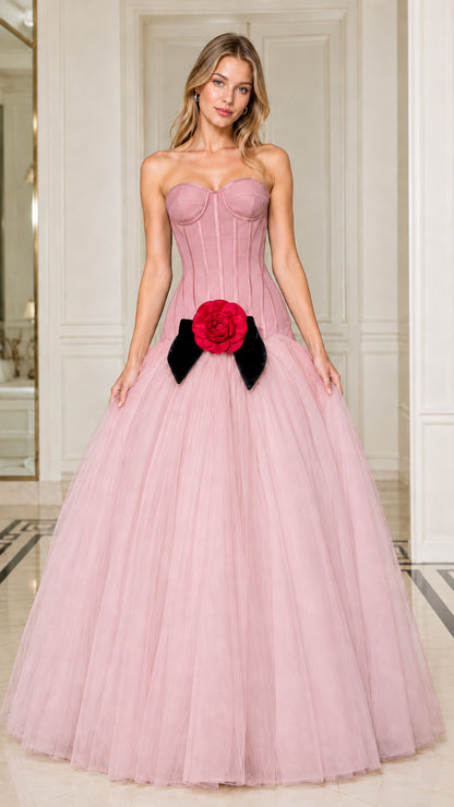 Model wearing blush pink strapless corset ball gown with red floral waist detail