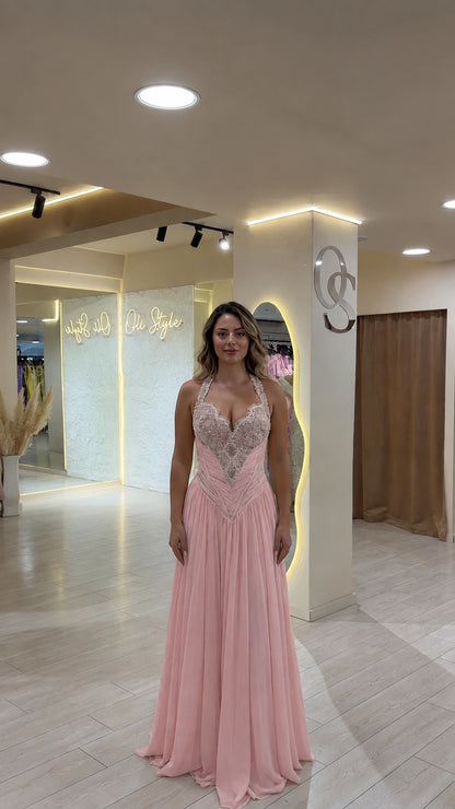 Model wearing soft blush pink halter embellished formal maxi gown