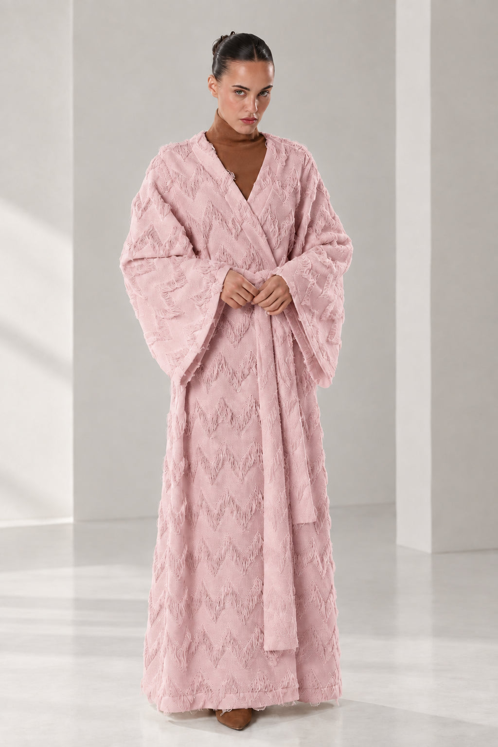 Front full view of woman wearing dusty pink textured chevron fringe maxi wrap robe