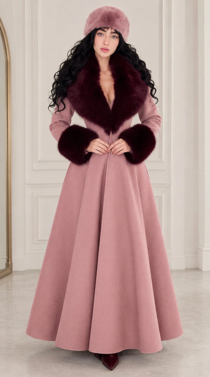 Front view of woman wearing dusty pink maxi coat with contrasting wine red faux fur trim