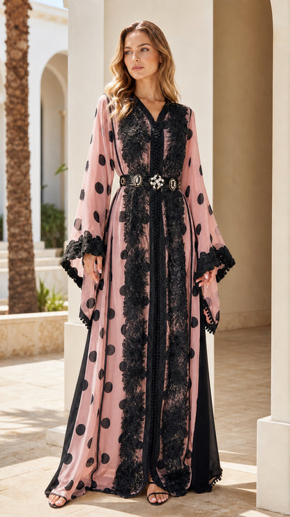 Full-length front view of woman wearing dusty pink polka dot kaftan with black lace trim