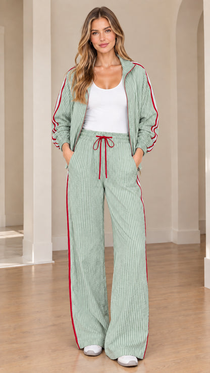 Model wearing sage green striped two-piece track set with contrast side stripes