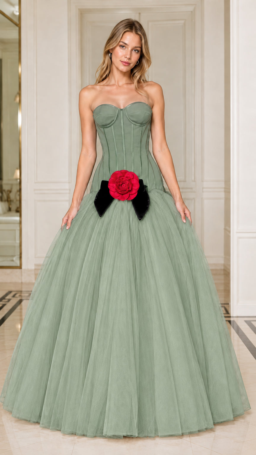 Model wearing sage green strapless corset tulle gown with red flower accent