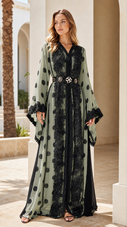 Full-length front view of woman wearing sage green polka dot kaftan with black lace trim