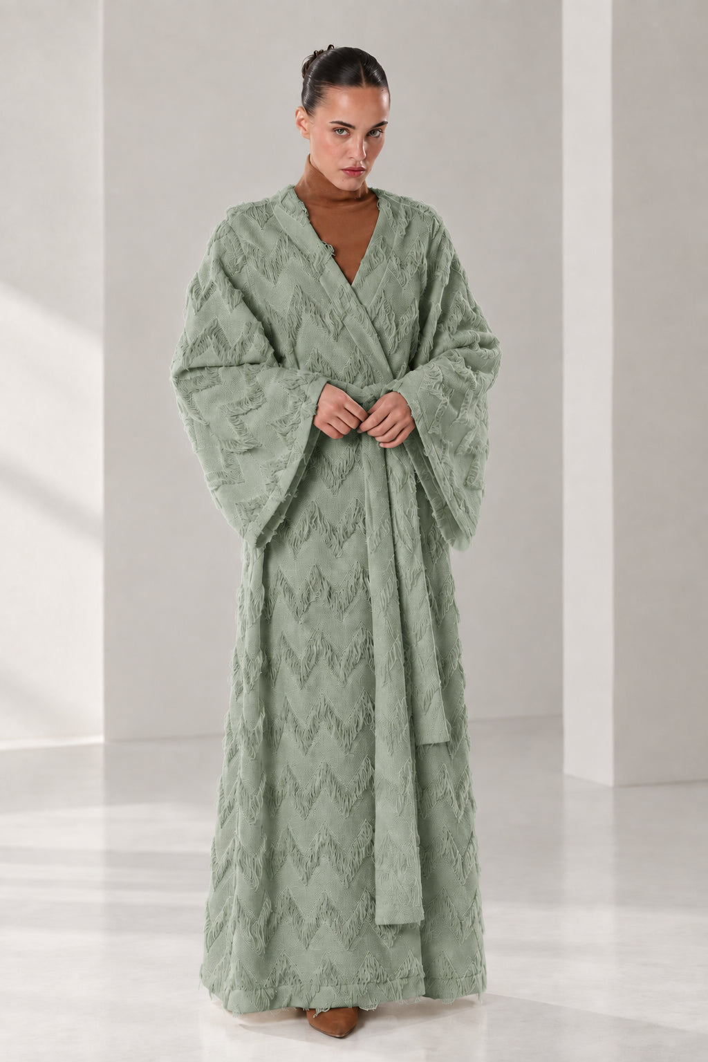 Front full view of woman wearing sage green textured chevron fringe maxi wrap robe