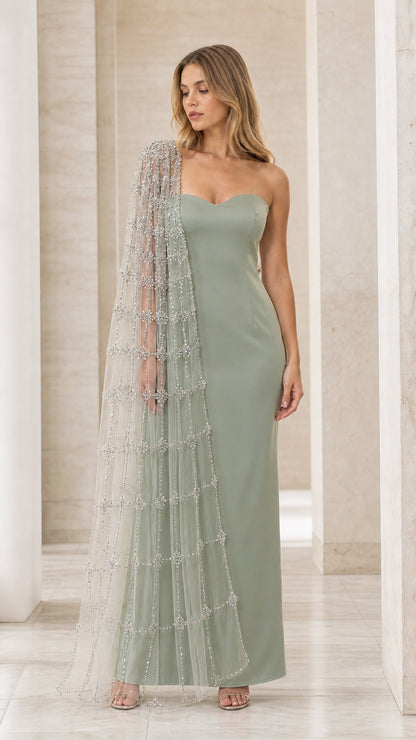 Model wearing sage green sweetheart formal gown with sheer embellished cape