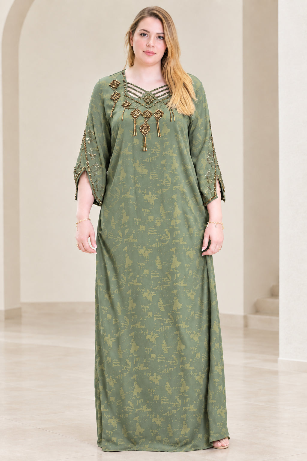 Front view of woman wearing sage green beaded strappy neckline kaftan dress